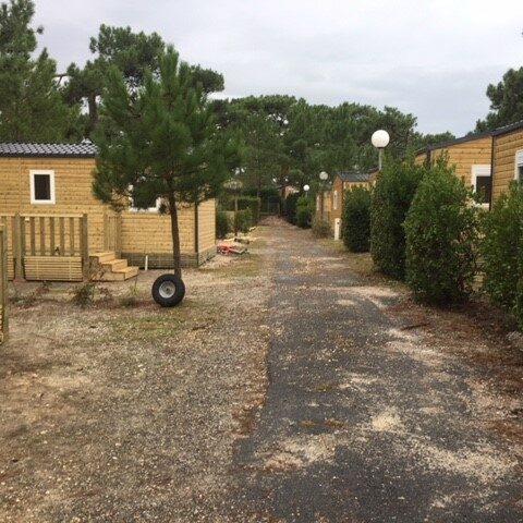 Mobil-home en bois avec terrasse, soubassement dans camping boisé